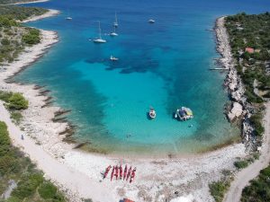 Kajaks am Strand in einer Bucht mit türkisblauem Wasser
