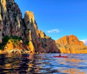 Kajakfahrer an Küste bei Sonnenuntergang