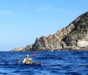 Kajakfahrerin an küste Korsikas